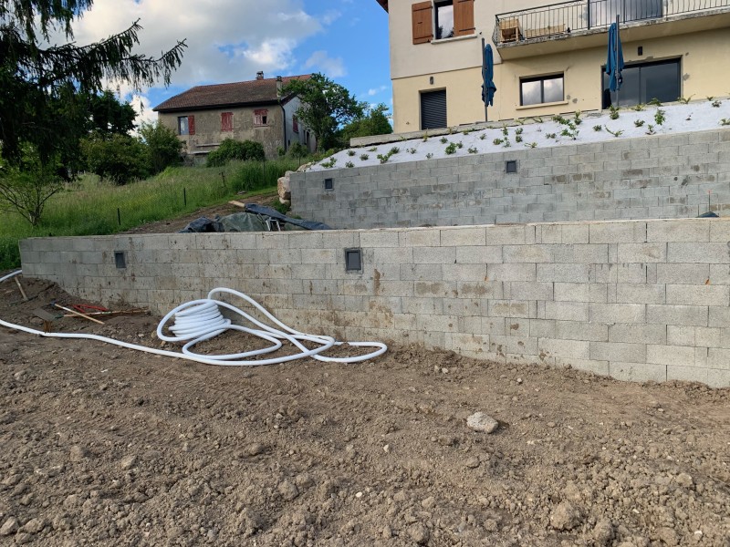 Travaux de terrassement avec blocs à bancher, dallage béton gravillonné XC1/C25/30 et escalier béton sur deux niveaux à Dommartin près de Lyon